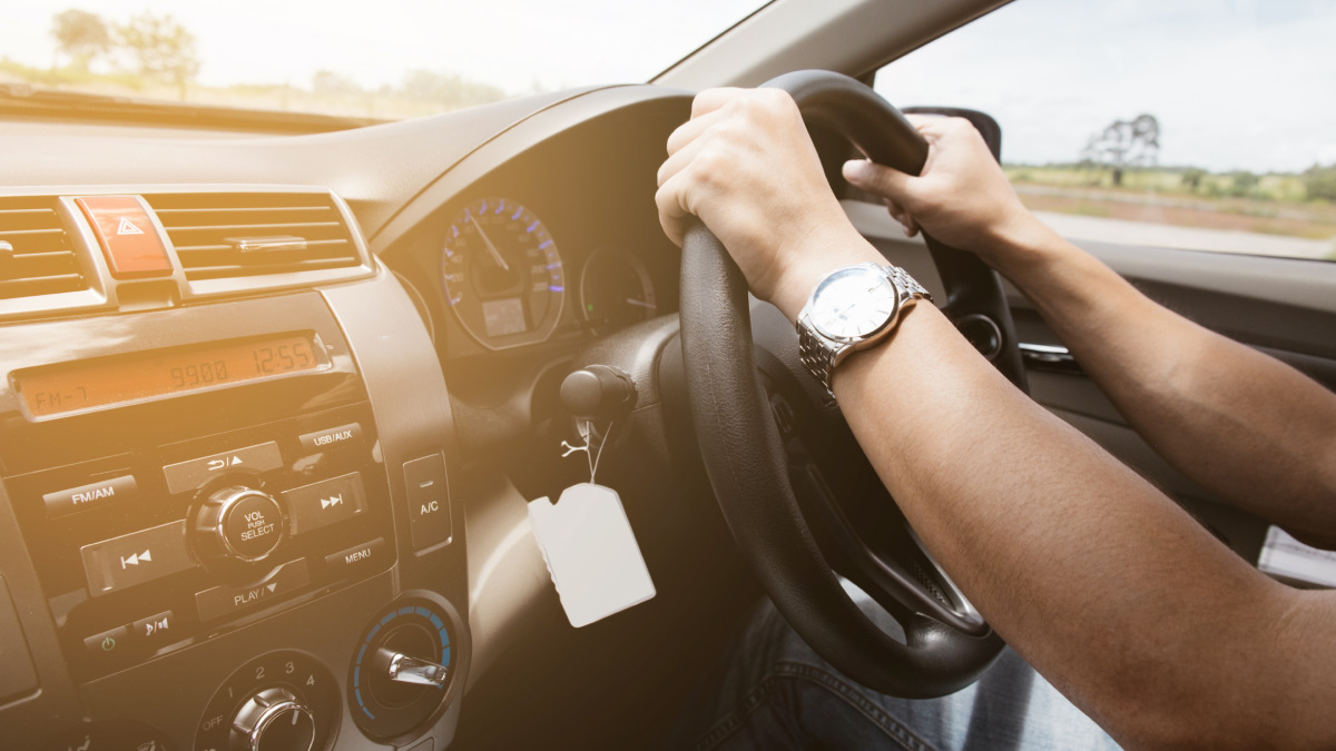 Male hands on steering wheel